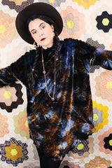 Long sleeve long length tie dye velvet top with a mock neck in a stretchy velvet material. Blue and brown colors with curly trim throughout.