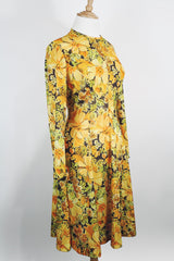 Women's vintage 1970's long sleeve knee length dress in a lightweight polyester material. All over yellow and orange floral print.