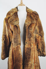 Women's vintage 1960's Apropos, Made in Korea label long sleeve knee length genuine fur coat with burnt orange leather trim and a tie belt.