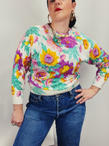 Women's vintage 1980's Sweater Teas label long sleeve white pullover acrylic sweater with all over large floral print in purple, yellow, and green.