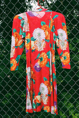 Women's vintage 1980's long sleeve mini dress with an attached tie neck. Red with all over floral print. Soft with shoulder pads.