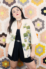 Women's vintage 1970's Tori Richard, Honolulu label cream colored long sleeve tunic blouse with floral print in the front and fabric buttons up the front.