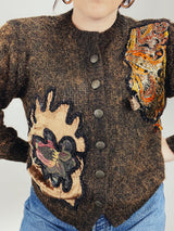 Women's vintage 1980's long sleeve brown orange wool cardigan with brass buttons and two abstract patches in the front.