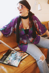 Women's vintage 1970's Cole of California label tie front blouse with balloon sleeves in purple, green, and orange colors and a lightweight polyester material.