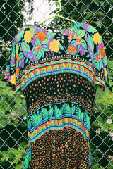 Women's vintage 1980's Carol Little label short sleeve midi length Summer dress with tropical floral print. Has a beaded wrap tie detail in the front.