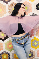 Women's vintage 1980's sheer silk material cape blouse in a light purple color. Has one hook and eye closure at neck with attached bow.