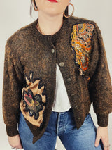 Women's vintage 1980's long sleeve brown orange wool cardigan with brass buttons and two abstract patches in the front.
