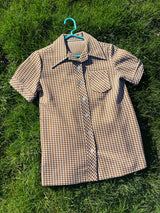Women's vintage 1970's short sleeve button up shirt blouse in brown and white checkered print polyester material.