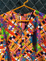 Women's vintage 1970's short sleeve mini length multicolored shift dress in polyester with v shaped neckline.