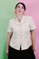 Women's vintage 1990's Sweet Suit label short sleeve button up blazer with double lapel and silver metal detail. In a light green and white all over checkered print.