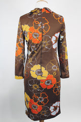 Women's vintage 1970's long sleeve knee length dress in a polyester material with a tie front neck. Brown color with all over yellow and orange flowers.