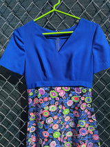Women's vintage 1970's short sleeve maxi dress with a blue top and a multicolored printed skirt in polyester.