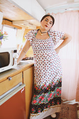 Women's vintage 1970's maxi length dress with flutter sleeves in white. Has an all over red and black ditsy floral print.