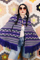 Women's vintage 1970's Made in Guatemala label purple and white printed poncho with fringe trim and two button closure across chest.