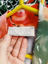 Women's vintage 1990's Val Mode Lingerie, Made in USA label short sleeve short length loungewear robe in an all over tropical floral print in orange and green with a matching tie belt.