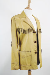 Men's or women's vintage 1950's long sleeve light tan colored genuine leather jacket with button front closure and fringe trim in front and back.