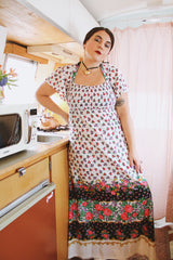 Women's vintage 1970's maxi length dress with flutter sleeves in white. Has an all over red and black ditsy floral print.