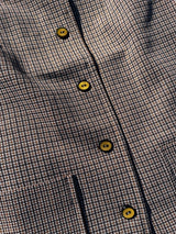 Women's vintage 1970's short sleeve button up shirt blouse in brown, white, and black gingham checkered polyester material with pockets.