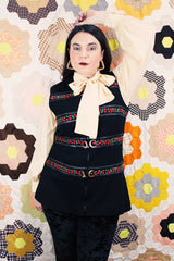 Women's vintage 1970's Palena Knitwear, Made in Hong Kong label sleeveless black wool vest with brass buckles closures up the front and floral trim details.