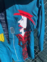 Women's vintage 1980's made in usa long sleeve blue blazer with one button closure and fully lined with large patches of people on front and back.