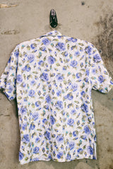 Women's vintage 1980's LORI by AM Casuals short sleeve button up blouse in white with all over blue floral print. Stretchy polyester material.