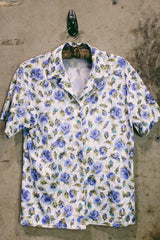 Women's vintage 1980's LORI by AM Casuals short sleeve button up blouse in white with all over blue floral print. Stretchy polyester material.