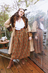 Women's vintage 1970's maxi length velvet skirt with an elastic waistband and matching tie belt. Orange with all over multicolored paisley print.