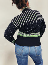 Women's vintage 1980's Demetre label long sleeve black pullover ski sweater with a half zip closure and white and green print all over.