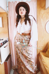 Women's vintage 1970's Saks Alley label long maxi length skirt in a tapestry material in orange colors and a paisley style print.