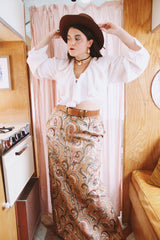 Women's vintage 1970's Saks Alley label long maxi length skirt in a tapestry material in orange colors and a paisley style print.