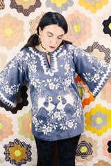 Women's vintage 1970's blue chambray tunic blouse with flared sleeves and a V shaped neckline. Has a white embroidered bird on the front.