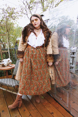 Women's vintage 1970's maxi length velvet skirt with an elastic waistband and matching tie belt. Orange with all over multicolored paisley print.