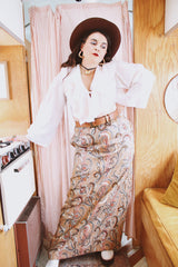 Women's vintage 1970's Saks Alley label long maxi length skirt in a tapestry material in orange colors and a paisley style print.