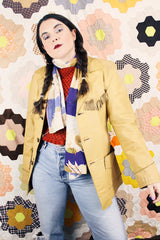 Men's or women's vintage 1950's long sleeve light tan colored genuine leather jacket with button front closure and fringe trim in front and back.