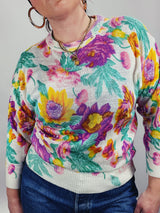 Women's vintage 1980's Sweater Teas label long sleeve white pullover acrylic sweater with all over large floral print in purple, yellow, and green.