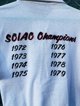 Women's or men's vintage 1970's short sleeve white polo t-shirt with half button closure and a graphic on the front left chest and one in the back.