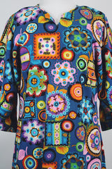 Women's vintage 1970's cotton material short sleeve maxi length dress with all over multicolored print. Has big flared sleeves and a V shaped neckline.