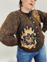 Women's vintage 1980's long sleeve brown orange wool cardigan with brass buttons and two abstract patches in the front.