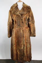 Women's vintage 1960's Apropos, Made in Korea label long sleeve knee length genuine fur coat with burnt orange leather trim and a tie belt.