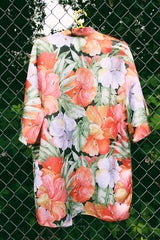 Women's vintage 1990's Val Mode Lingerie, Made in USA label short sleeve short length loungewear robe in an all over tropical floral print in orange and green with a matching tie belt.