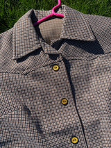 Women's vintage 1970's short sleeve button up shirt blouse in brown, white, and black gingham checkered polyester material with pockets.
