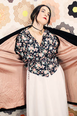 Women's vintage 1950's "365" by All-State label long sleeve knee length black velvet duster jacket with button front closure and pink satin liner.