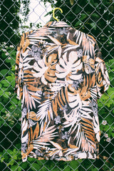 Women's vintage 1990's Glaser label short sleeve button up blouse with collar in a sheer material. All over black, white, and brown tropical flower print.