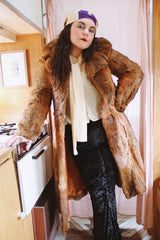 Women's vintage 1960's Apropos, Made in Korea label long sleeve knee length genuine fur coat with burnt orange leather trim and a tie belt.