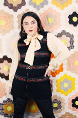 Women's vintage 1970's Palena Knitwear, Made in Hong Kong label sleeveless black wool vest with brass buckles closures up the front and floral trim details.