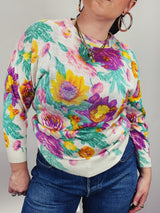 Women's vintage 1980's Sweater Teas label long sleeve white pullover acrylic sweater with all over large floral print in purple, yellow, and green.