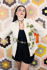 Women's vintage 1970's Tori Richard, Honolulu label cream colored long sleeve tunic blouse with floral print in the front and fabric buttons up the front.