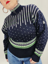 Women's vintage 1980's Demetre label long sleeve black pullover ski sweater with a half zip closure and white and green print all over.