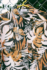 Women's vintage 1990's Glaser label short sleeve button up blouse with collar in a sheer material. All over black, white, and brown tropical flower print.