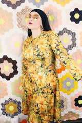 Women's vintage 1970's long sleeve knee length dress in a lightweight polyester material. All over yellow and orange floral print.